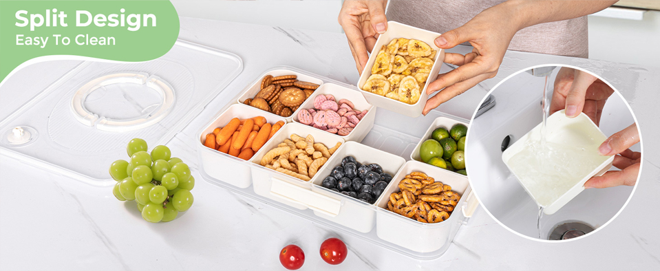 A divided snack box with six removable compartments, each filled with different snacks including banana chips, cookies, pink sweets, baby carrots, peanuts, blueberries, pretzels, and green grapes. A pair of hands lifts one compartment, and a small inset shows a section being rinsed under running water to highlight the easy‑clean split design.
